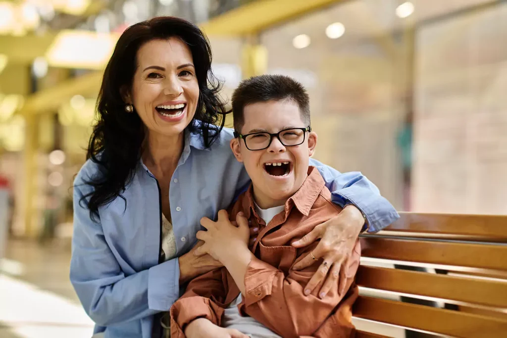 A disabled boy and his mother smiling